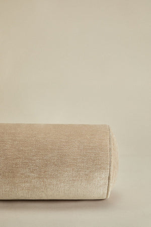 Lesoto bolster cushion – full side view on beige background, beige velvet with white piping ends