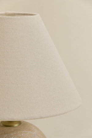 Marvexi table lamp – close-up of pitted travertine stone sphere base showing unique fossils, veining, and warm sandy-beige mineral texture