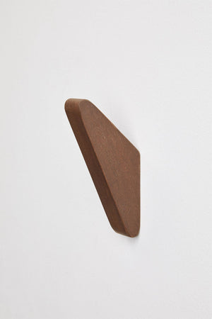 Brana wooden wall hooks – single dark walnut hook mounted on white wall, side profile view showing organic fin silhouette and depth
