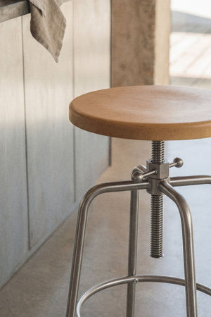 Bangalore high stool – close-up of screw adjustment mechanism from side angle, lifestyle setting