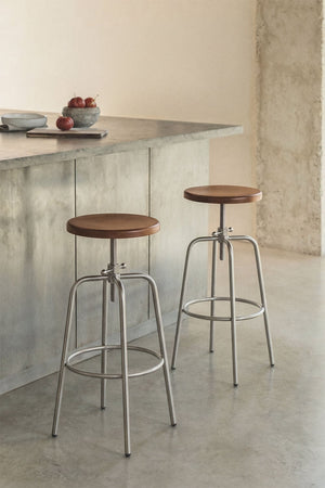 Bangalore high stool – three-quarter front view on white background, natural beechwood seat, lower height position