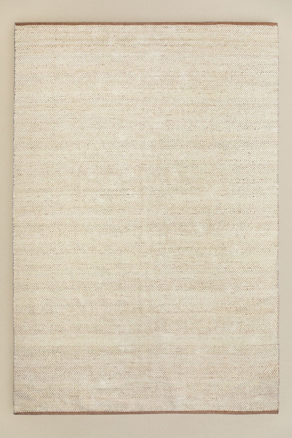 Kalina rug 200x300 cm – overhead flat lay on beige background, full rectangular shape, ivory herringbone weave with warm caramel border