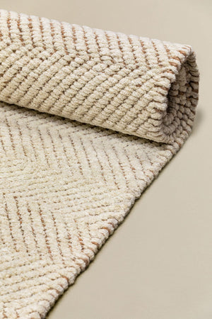 Kalina rug – close-up of rolled corner showing herringbone weave structure on both face and reverse, jute backing visible