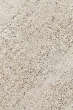 Daroca round rug – close-up of dense hand-woven pile with walnut side table base in corner