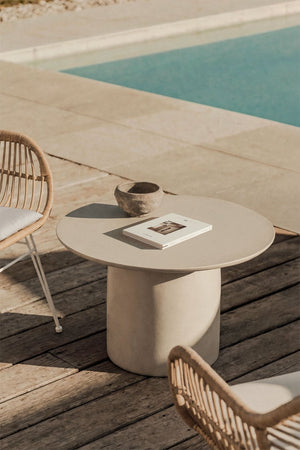 Layana round concrete coffee table styled beside a pool