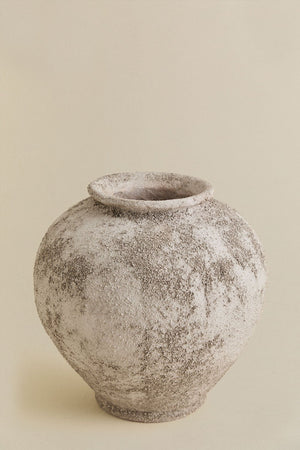 Filis ceramic vase – macro close-up of lower body and base showing the coarse, salt-and-pepper sand texture and subtle tonal variation across the surface