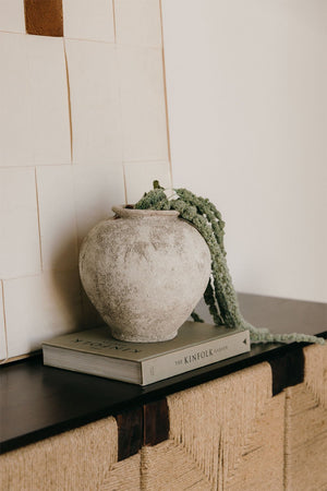 Filis ceramic vase – full studio shot on warm beige background showing round belly, narrow neck opening and raw granular sand-texture finish, no styling